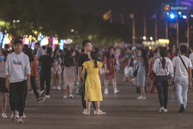 Chùm ảnh: Phố đi bộ Nguyễn Huệ vẫn đông kín người giữa những ngày tâm điểm dịch virus corona, một số người phớt lờ việc đeo khẩu trang phòng bệnh - Ảnh 1.