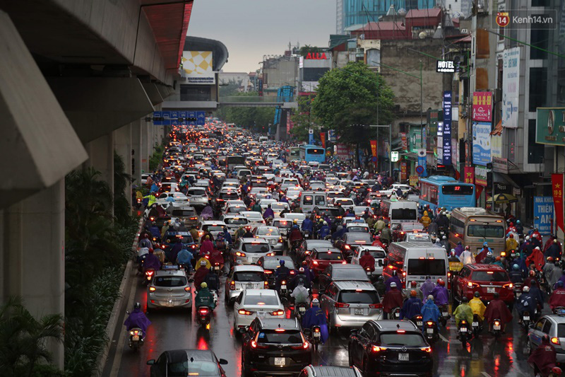 Hà Nội tắc đường kinh hoàng, người dân khổ sở đi làm trong cơn mưa lớn - Ảnh 2.