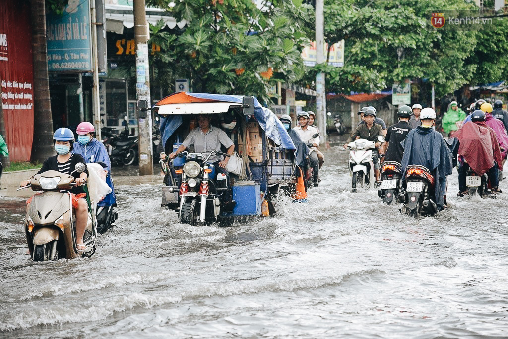 Người Sài Gòn té ngã trên đường ngập sâu, bỏ lại xe máy nằm lăn lóc dưới nước để bảo vệ đồ đạc - Ảnh 1.