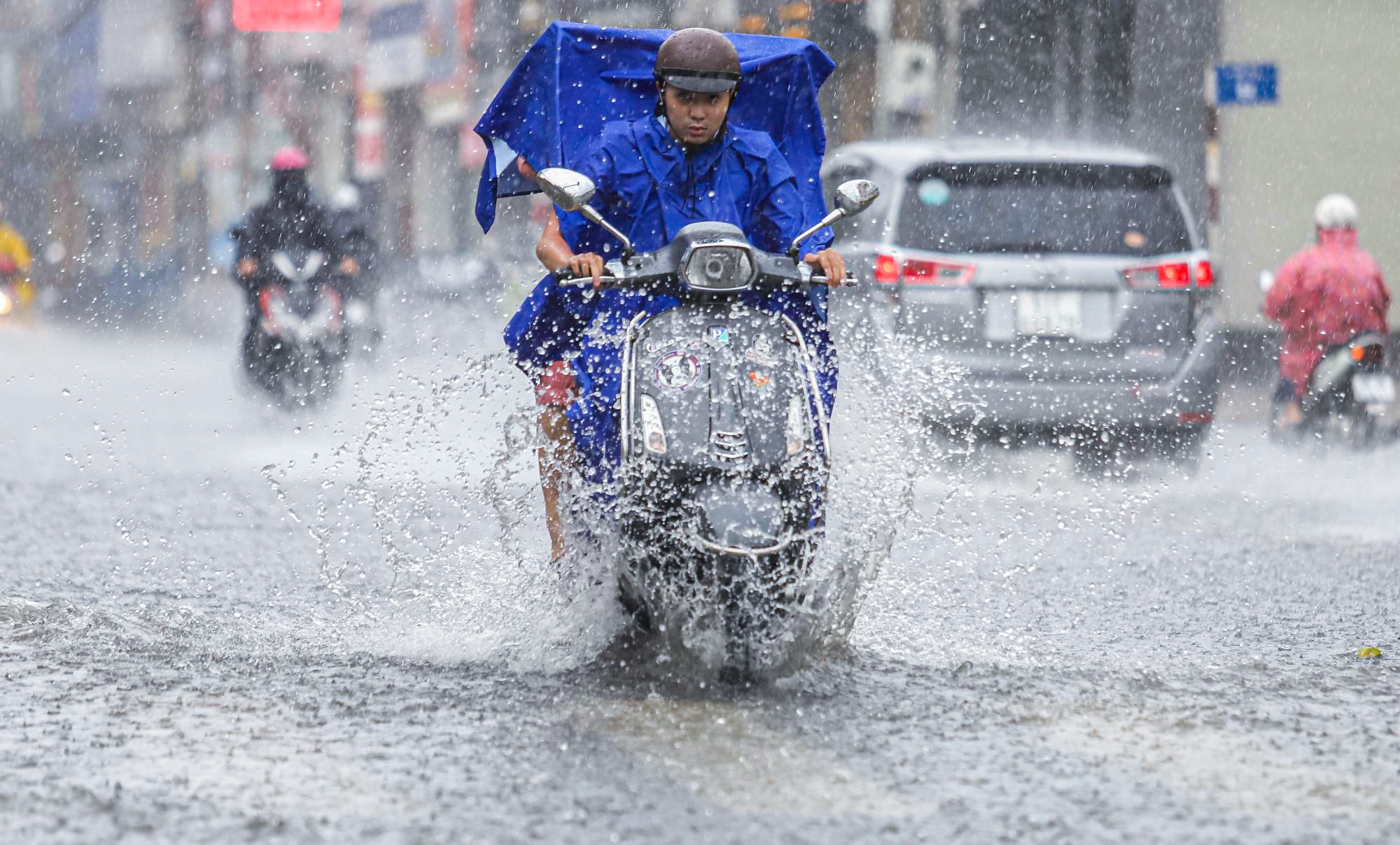 [ẢNH] Nước chảy xiết kéo nhiều xe máy đổ nhào giữa phố Sài Gòn, người dân dắt bộ cho an toàn - Ảnh 1.