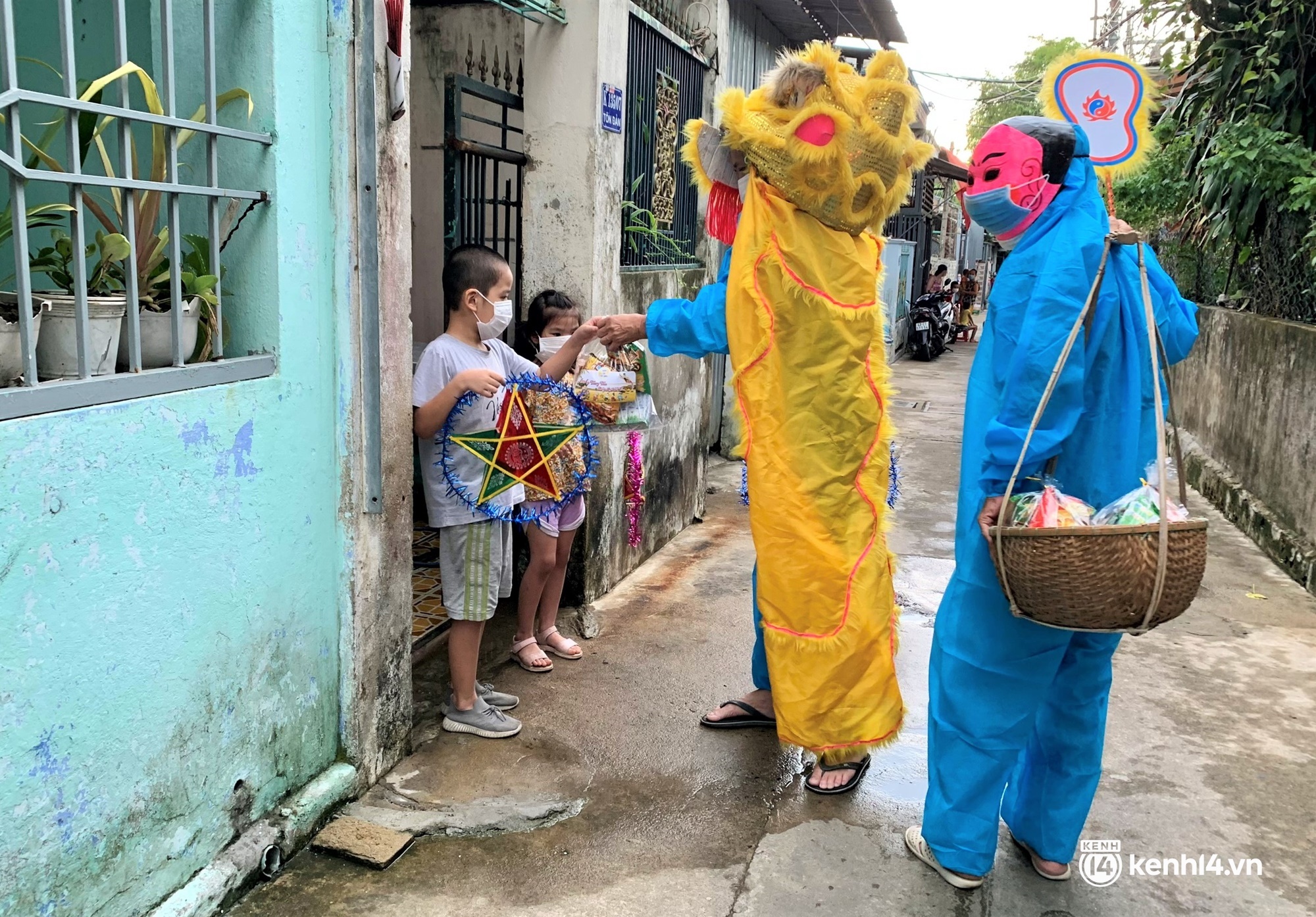 Ảnh: Tết Trung thu đặc biệt, ông địa cùng chú lân mặc đồ bảo hộ kín mít đến từng nhà tặng quà cho trẻ nhỏ - Ảnh 1.