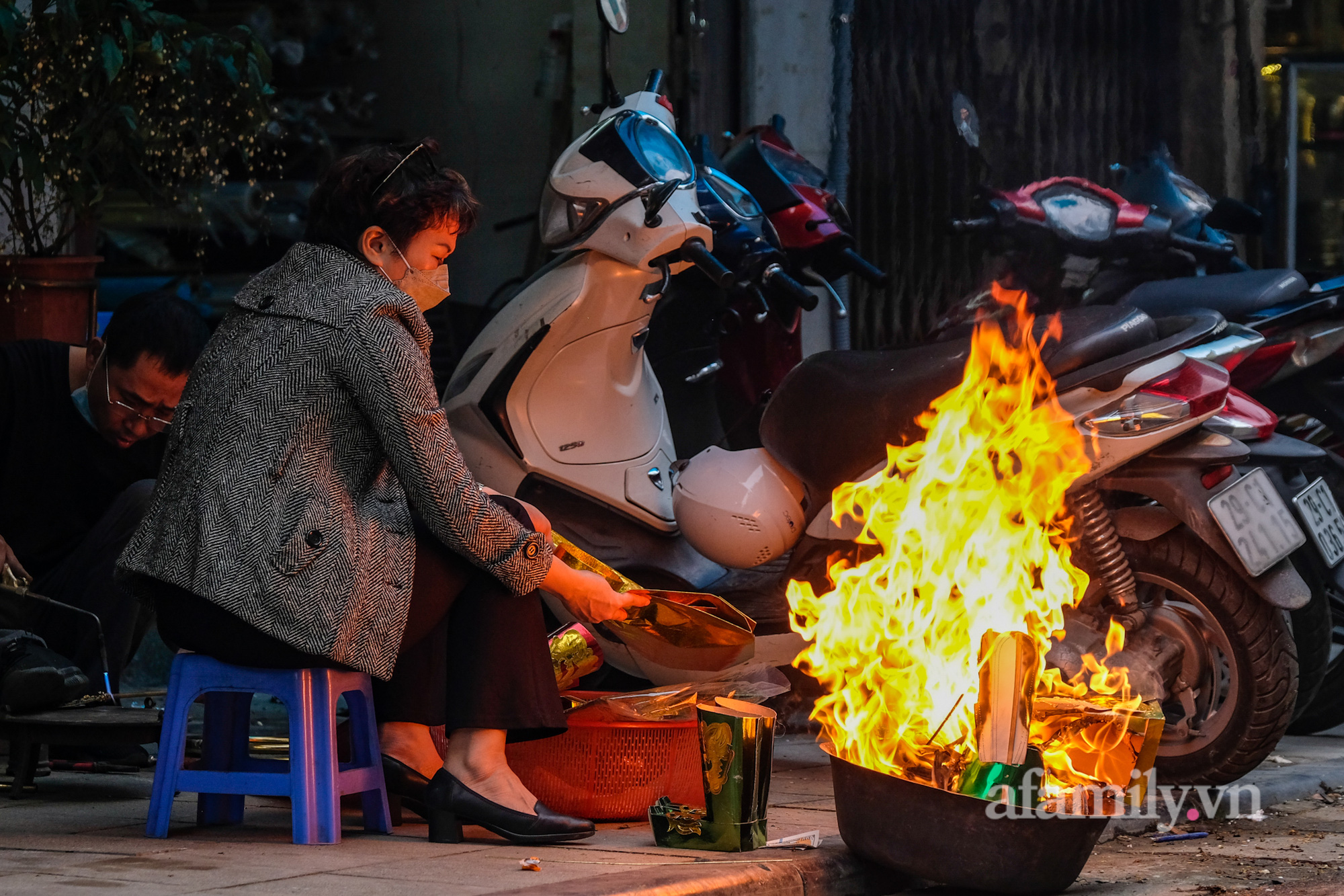 Bất chấp nguy hiểm, người Hà Nội ra gần giữa đường để đốt vàng mã tiễn ông Công ông Táo khiến người đi đường không khỏi hú vía - Ảnh 3.