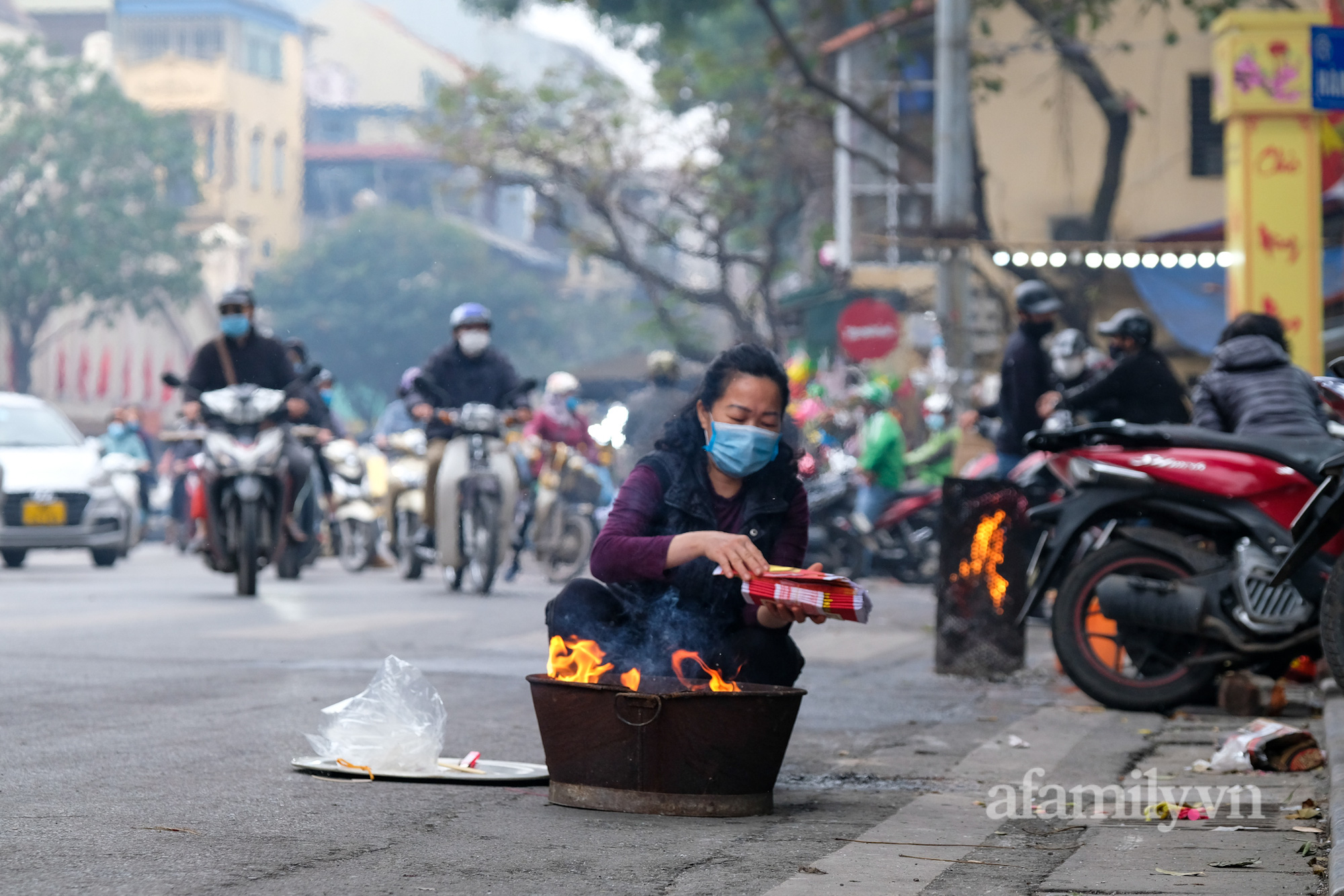 Bất chấp nguy hiểm, người Hà Nội ra gần giữa đường để đốt vàng mã tiễn ông Công ông Táo khiến người đi đường không khỏi hú vía - Ảnh 2.