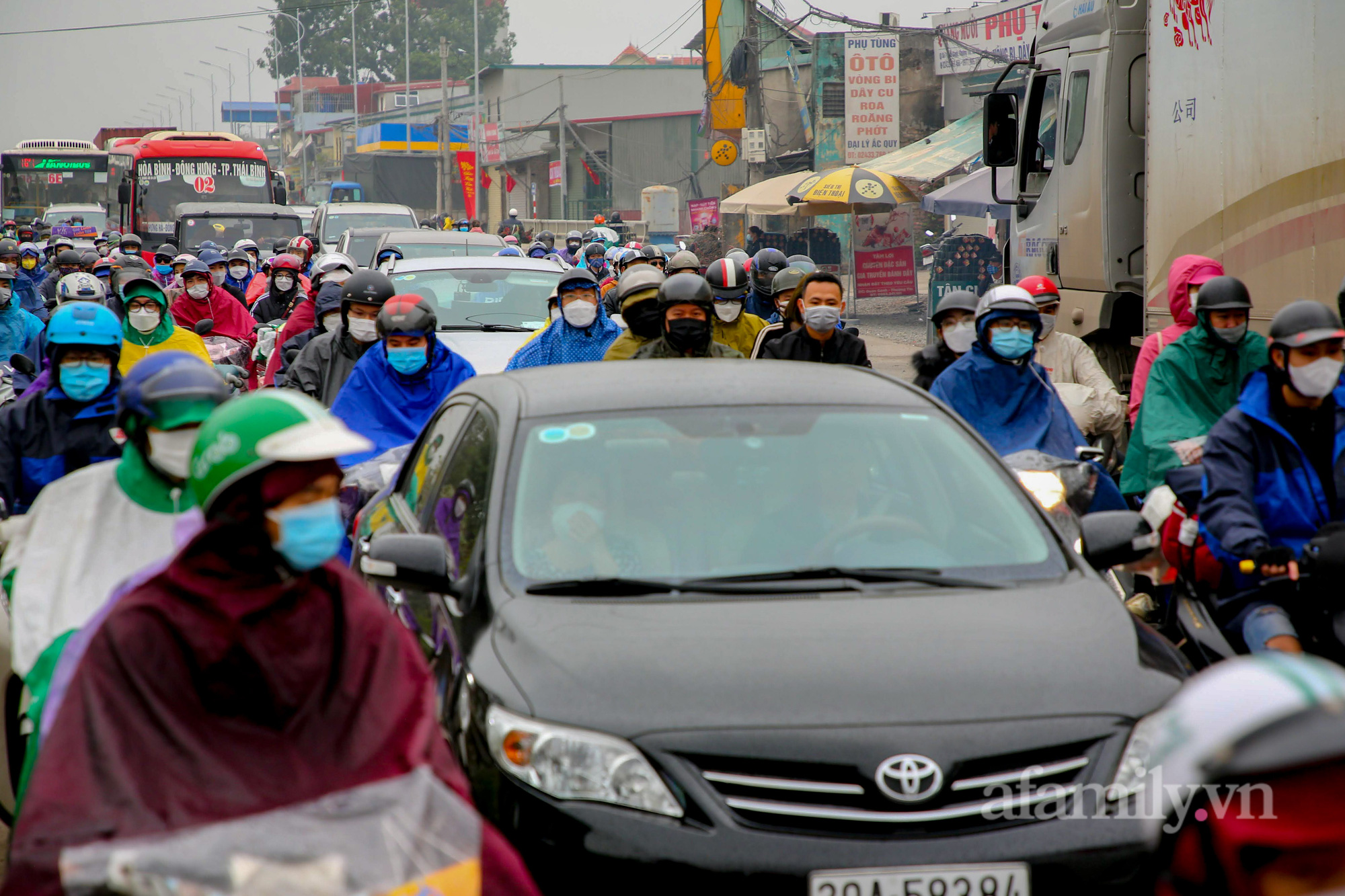 Hà Nội: Hàng nghìn người chạy xe máy trùm kín áo mưa, ùn ùn rời phố về quê ăn Tết - Ảnh 7.