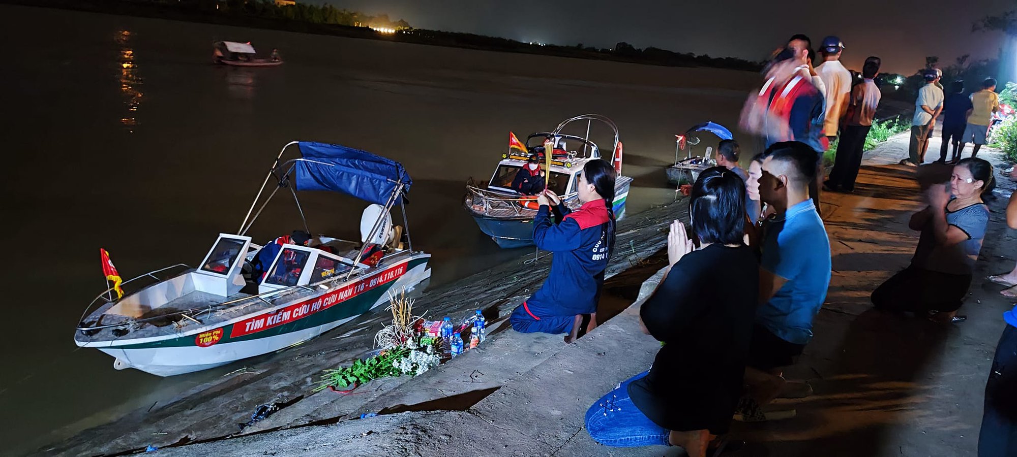 Thành viên đội cứu hộ 116 Thái Bình đang giúp gia đình nạn nhân trong việc tìm kiếm