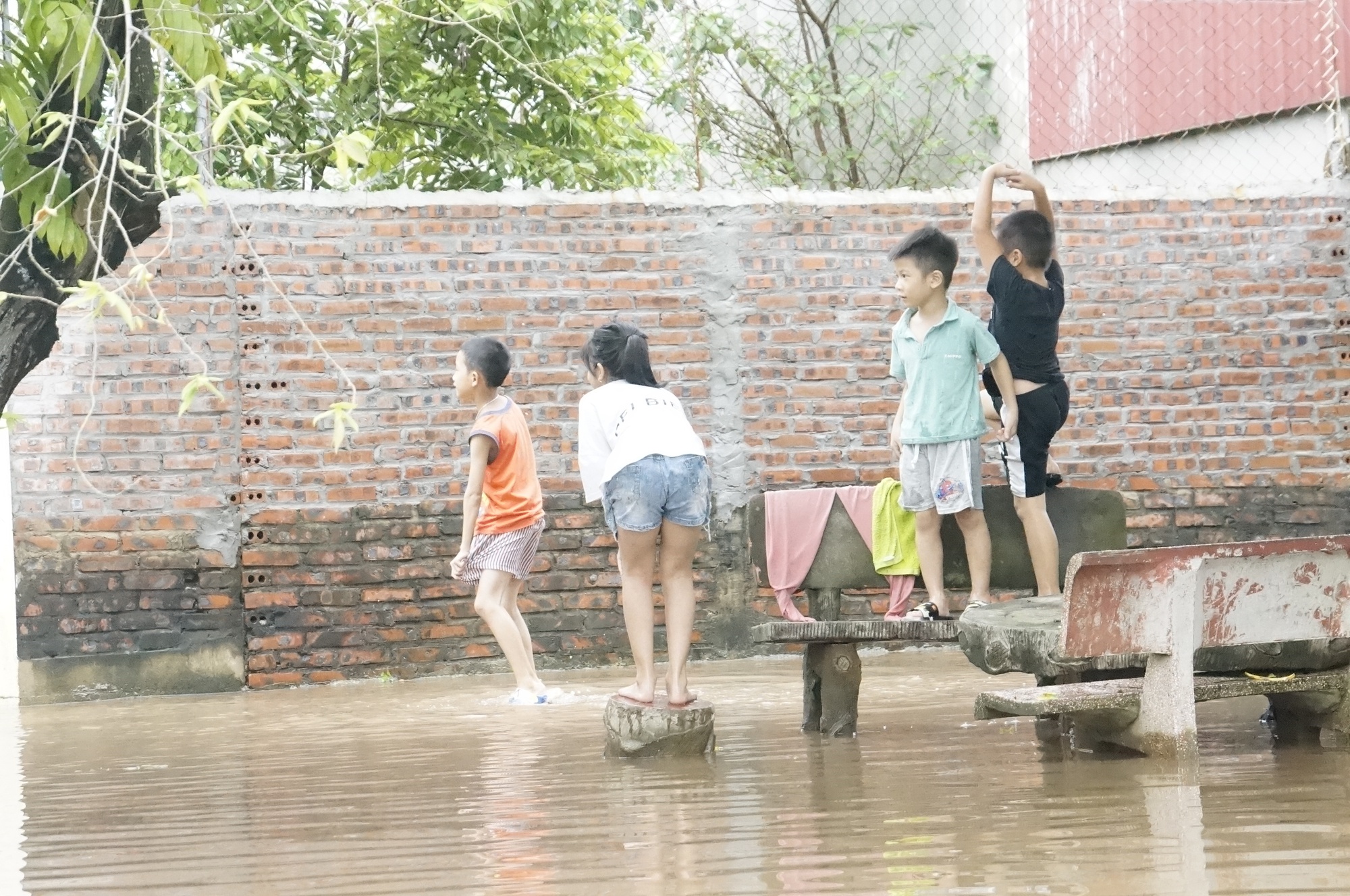 Trẻ em nô đùa lúc nước dâng cao cần phải có sự giám sát của người lớn