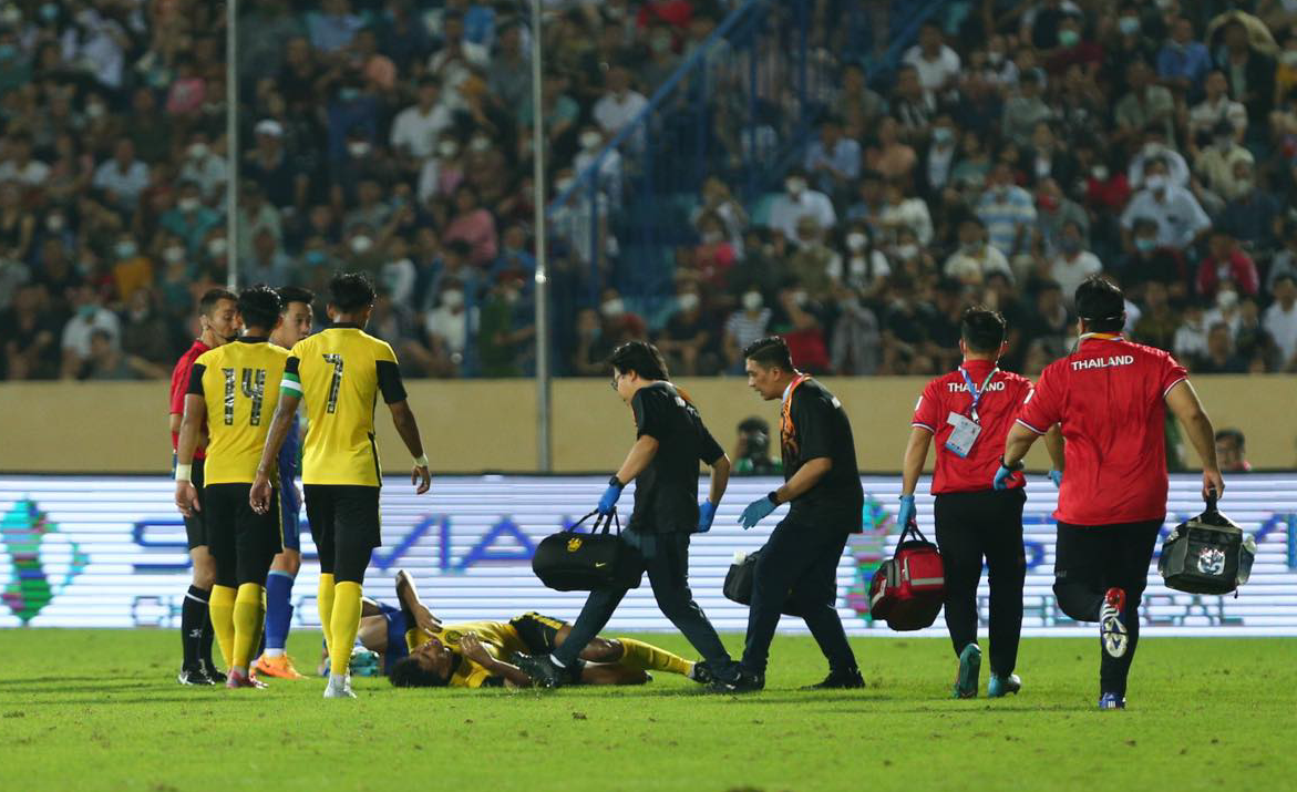 Cầu thủ U23 Malaysia chấn thương đau đớn phải đi cấp cứu ngay ngày đầu ra quân ở SEA Games 31 - Ảnh 1.