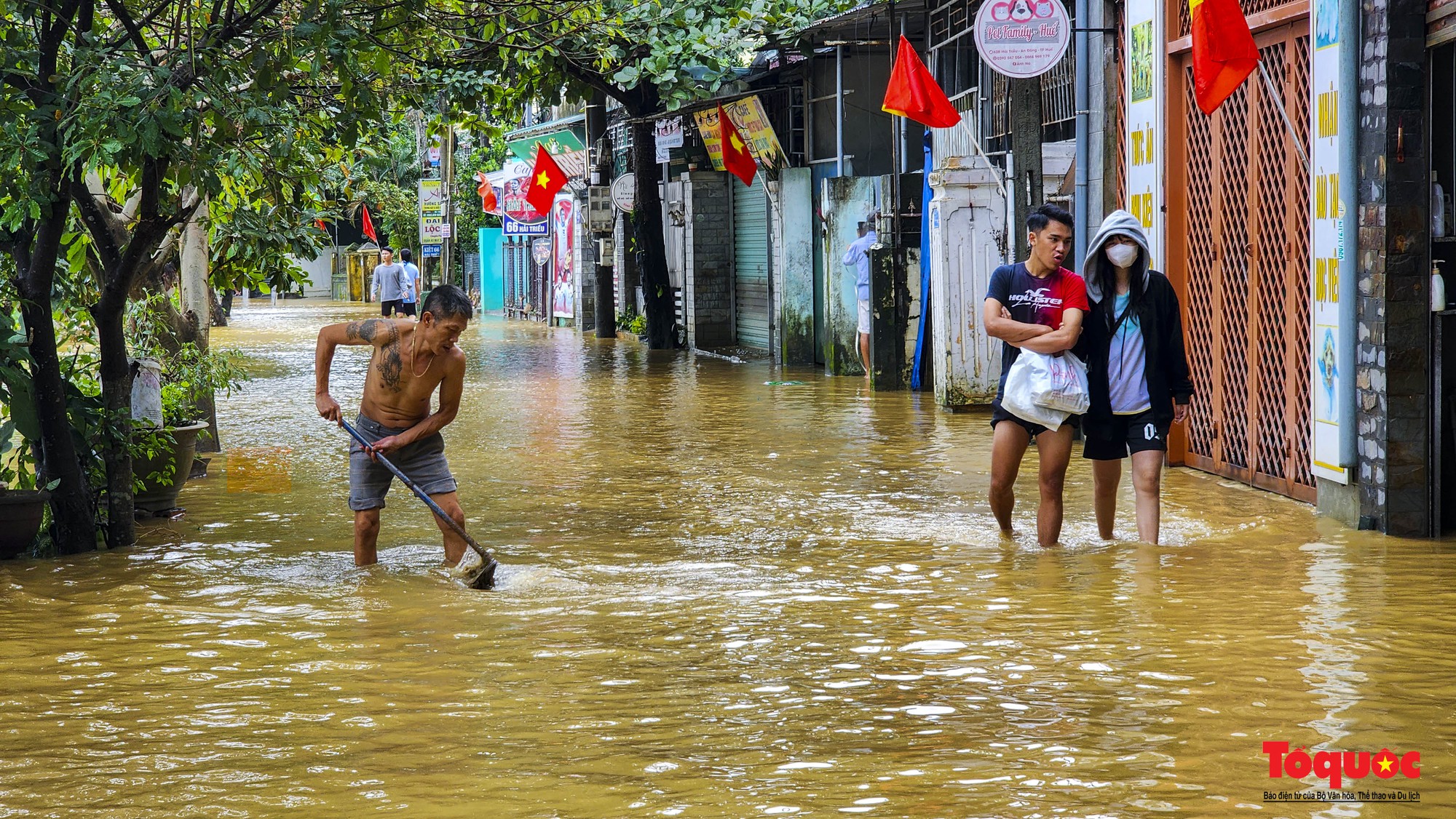 Nước lũ rút chậm, người dân TP Huế bì bõm dọn dẹp, đi mua lương thực - Ảnh 17.