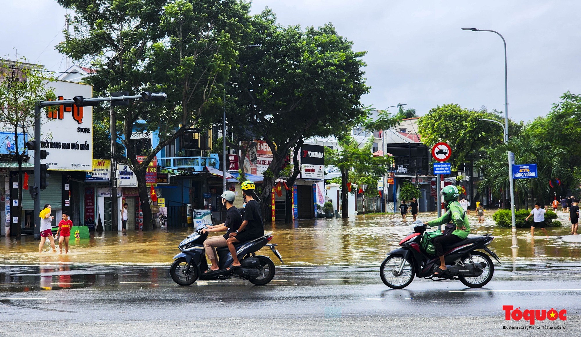 Nước lũ rút chậm, người dân TP Huế bì bõm dọn dẹp, đi mua lương thực - Ảnh 1.