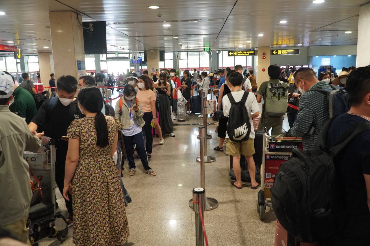 Sân bay Tân Sơn Nhất bắt đầu &quot;nóng&quot;, người dân mệt mỏi xếp hàng chờ làm thủ tục check-in  - Ảnh 1.
