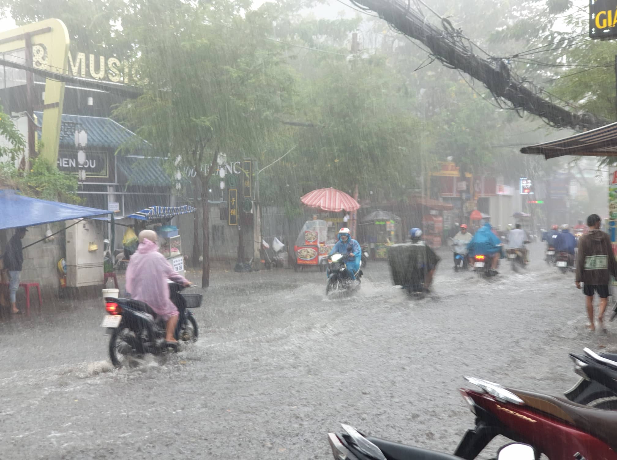 Mưa lớn sau chuỗi ngày nắng nóng, người dân TP.HCM lại bì bõm lội nước vì đường ngập  - Ảnh 1.