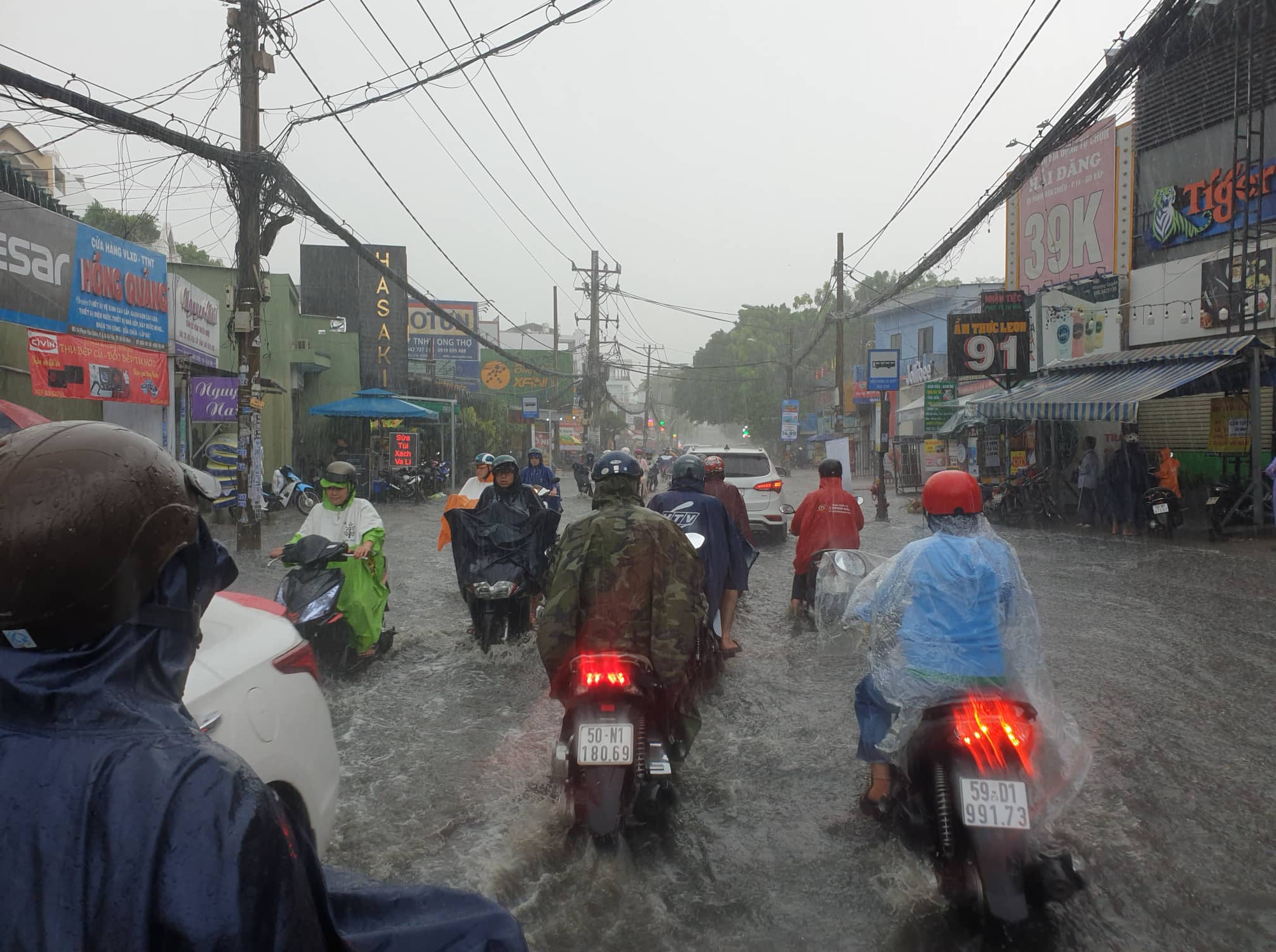 Mưa lớn sau chuỗi ngày nắng nóng, người dân TP.HCM lại bì bõm lội nước vì đường ngập  - Ảnh 2.