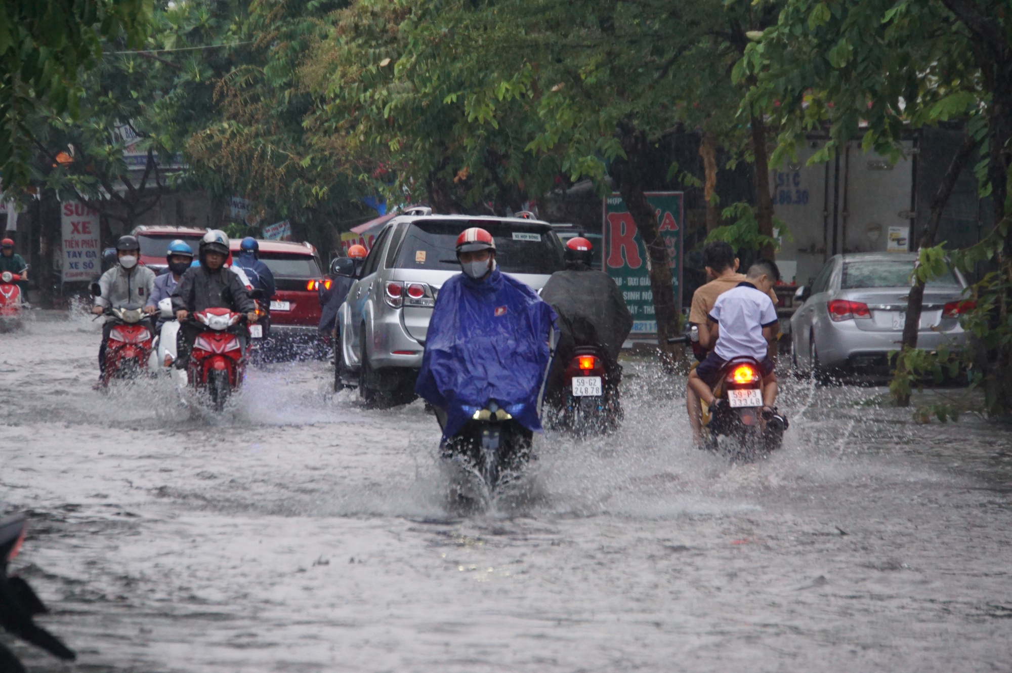 Mưa lớn sau chuỗi ngày nắng nóng, người dân TP.HCM lại bì bõm lội nước vì đường ngập  - Ảnh 3.