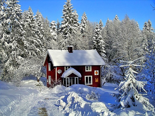 Một căn nhà sơn màu đỏ nội bật giữa lớp tuyết trắng tại Thụy Điển