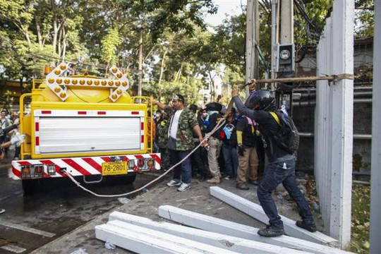 <br />
Người biểu tình giật đổ rào chắn của sân vận động sáng 26-12. Ảnh: REUTERS