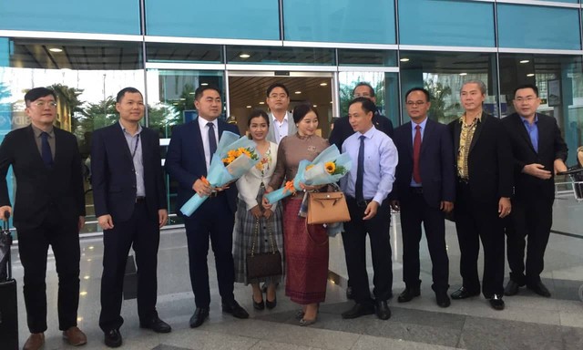 Phó giám đốc Sở Du lịch Đà Nẵng - ông Nguyễn Xuân Bình tặng hoa và quà lưu niệm cho những vị khách đầu tiên của chuyến bay.