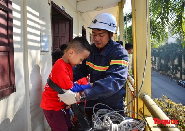 Các em nhỏ học kỹ năng đu dây thoát hiểm khi có sự cố cháy từ nhà cao tầng - Ảnh 2.