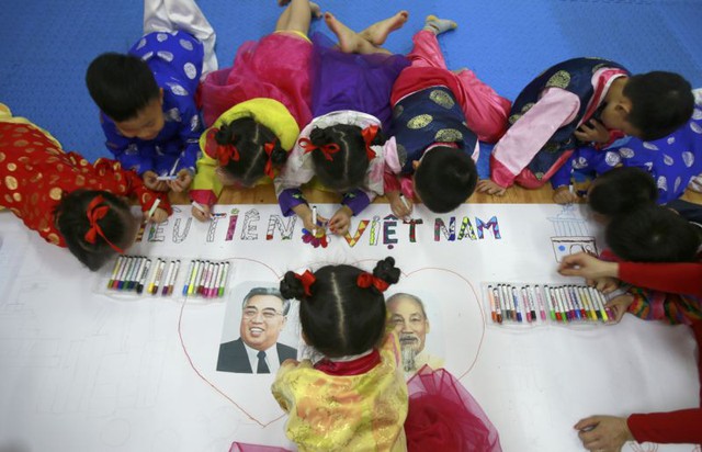 AP cận cảnh trẻ em Hà Nội hào hứng đón chờ Chủ tịch Triều Tiên Kim Jong-un - Ảnh 3.