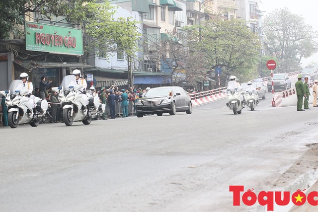 Đoàn xe chở Chủ tịch Kim Jong-un tiến về trung tâm Hà Nội giữa cờ hoa rực rỡ - Ảnh 1.