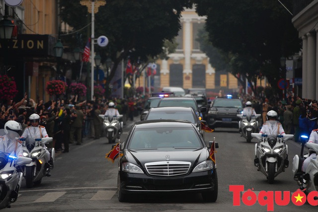 Đoàn xe chở Chủ tịch Kim Jong-un tiến về trung tâm Hà Nội giữa cờ hoa rực rỡ - Ảnh 2.