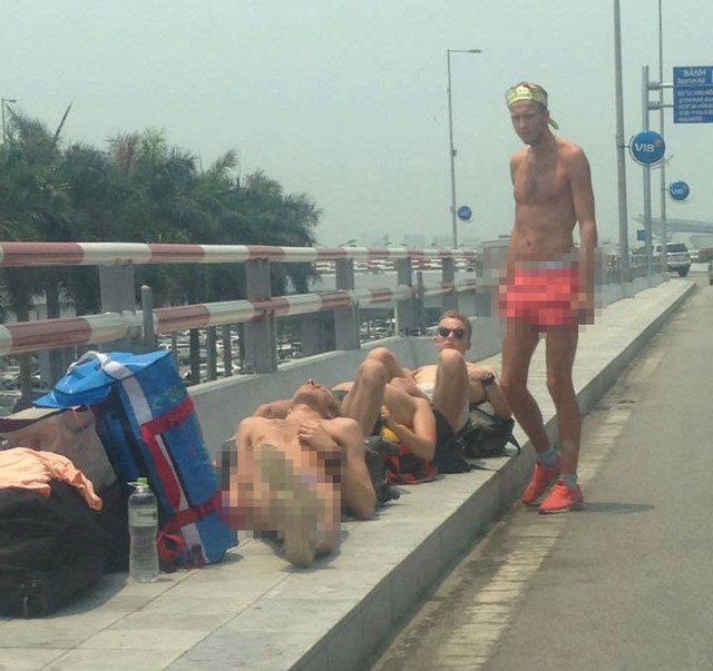 Một nhóm du khách nước ngoài nằm phơi nắng ngả ngớn trên đường vào sân bay Nội Bài - Ảnh 1.