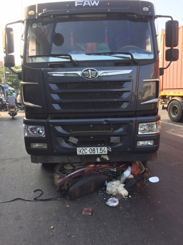 Xe máy bị cuốn vào gầm xe tải, một phụ nữ bị thương nặng - Ảnh 1.