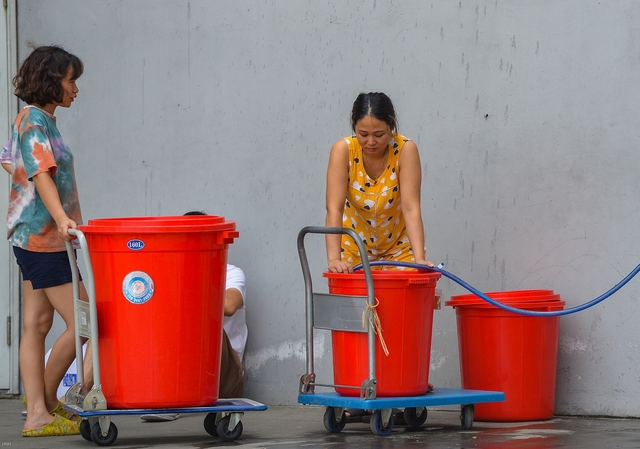 Hà Nội: Người dân mang theo xô, thùng lỉnh kỉnh đứng xếp hàng giữa trưa đợi lấy nước - Ảnh 6.