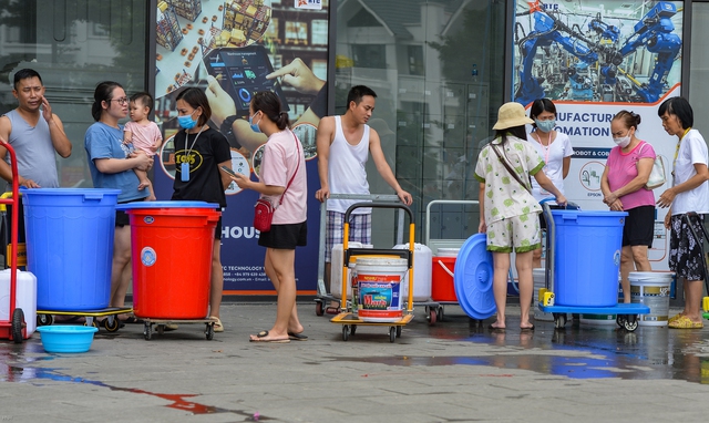 Hà Nội: Người dân mang theo xô, thùng lỉnh kỉnh đứng xếp hàng giữa trưa đợi lấy nước - Ảnh 2.