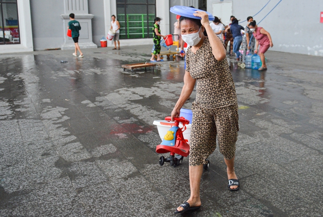 Ảnh: Hàng trăm người dân ở chung cư Hà nội đội mưa, xếp hàng chờ lấy nước sạch - Ảnh 11.