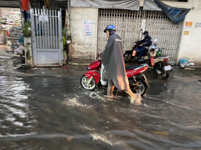 Người dân TP.HCM vật vã trong trong nước ngập và kẹt xe sau cơn mưa lớn - Ảnh 9.