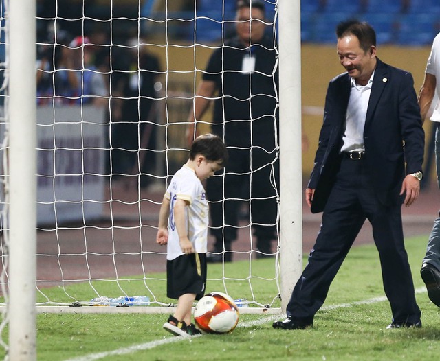 Bầu Hiển cùng cháu nội đá bóng trên sân Hàng Đẫy sau trận đấu của Hà Nội FC - Ảnh 1. Bầu Hiển cùng cháu nội đá bóng trên sân Hàng Đẫy sau trận đấu của Hà Nội FC - Ảnh 1.