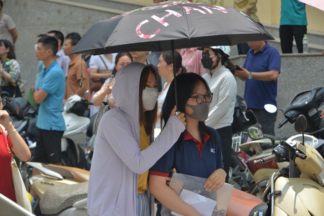 Nỗi lòng cha mẹ ngày con thi vào lớp 10: Nắng gần 40 độ trú trong bóng râm, rải áo mưa xuống nền đất nóng đợi tin con - Ảnh 11.