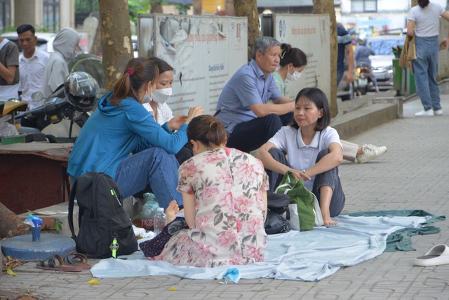 Nỗi lòng cha mẹ ngày con thi vào lớp 10: Nắng gần 40 độ trú trong bóng râm, rải áo mưa xuống nền đất nóng đợi tin con - Ảnh 5.