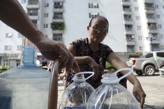 Người dân xách can, thùng nhựa,… đội nắng dưới tiết trời gần 40 độ C để lấy nước sử dụng  - Ảnh 3.