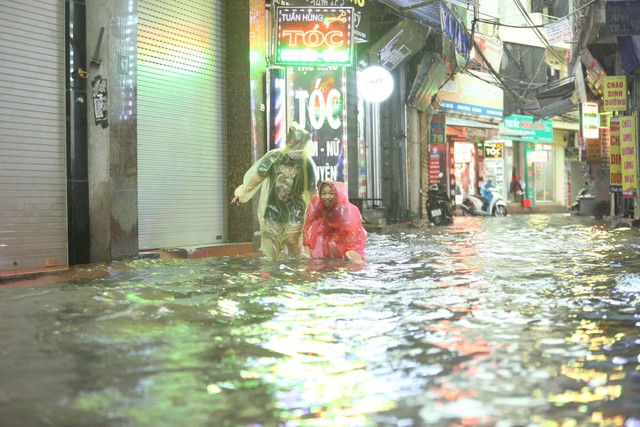 Hà Nội mưa trắng trời, phố phường ngập lụt, xe cộ &quot;bì bõm&quot; lội trong nước  - Ảnh 14.