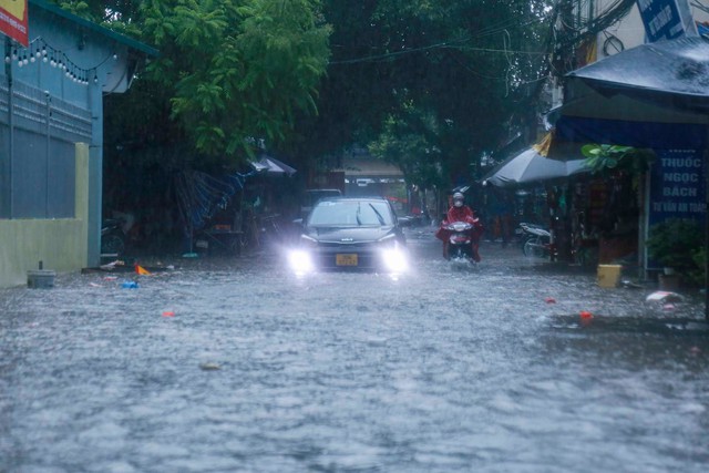 Hà Nội mưa trắng trời, phố phường ngập lụt, xe cộ &quot;bì bõm&quot; lội trong nước  - Ảnh 1.