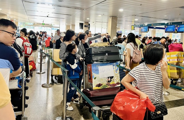 Sân bay Tân Sơn Nhất đông nghịt sáng 27 Tết, nhiều người sợ trễ ra sớm 4 tiếng để làm thủ tục - Ảnh 3.