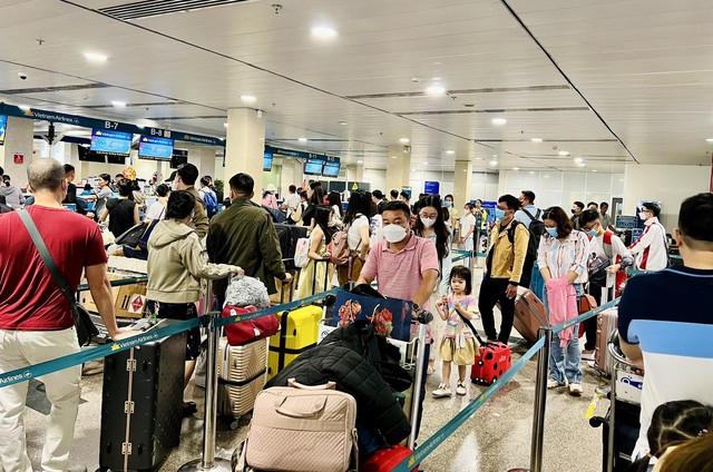 Sân bay Tân Sơn Nhất đông nghịt sáng 27 Tết, nhiều người sợ trễ ra sớm 4 tiếng để làm thủ tục - Ảnh 1.