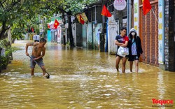 Nước lũ rút chậm, người dân TP Huế bì bõm dọn dẹp, đi mua lương thực
